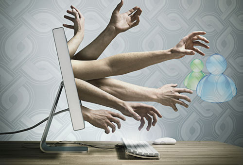 Hands reaching out of a computer screen --- Image by © Solus-Veer/Corbis