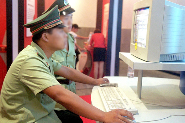 Chinese policemen surf the Internet at a computer